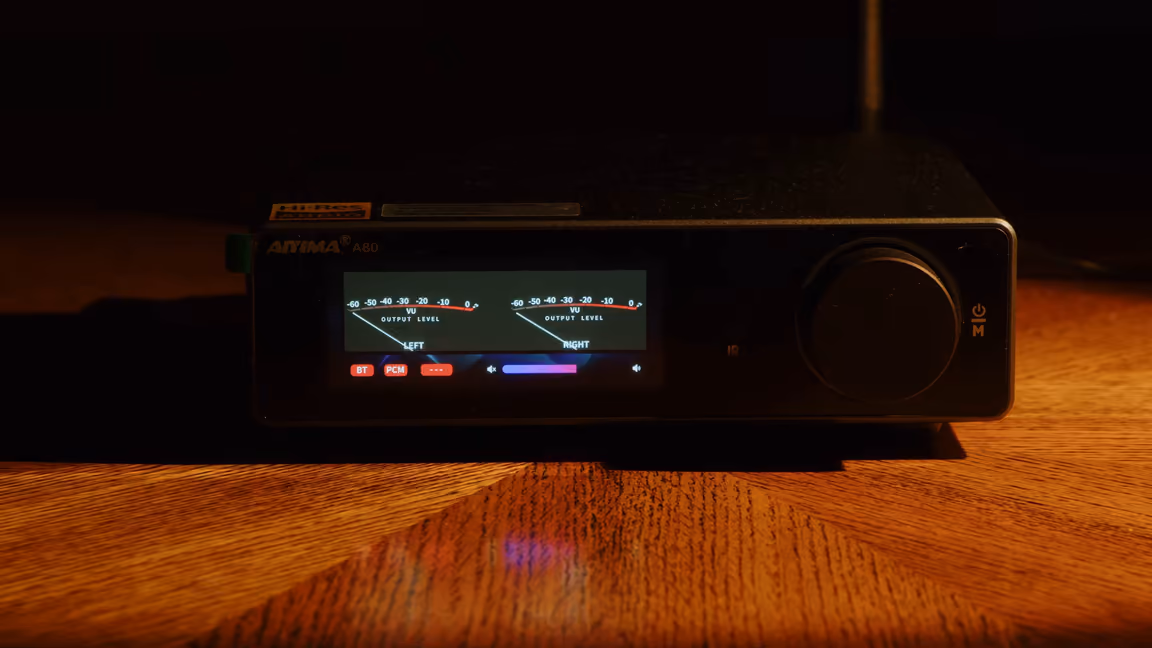 AIYIMA A80 integrated amplifier from the front, its two VU meters lit beside the volume knob