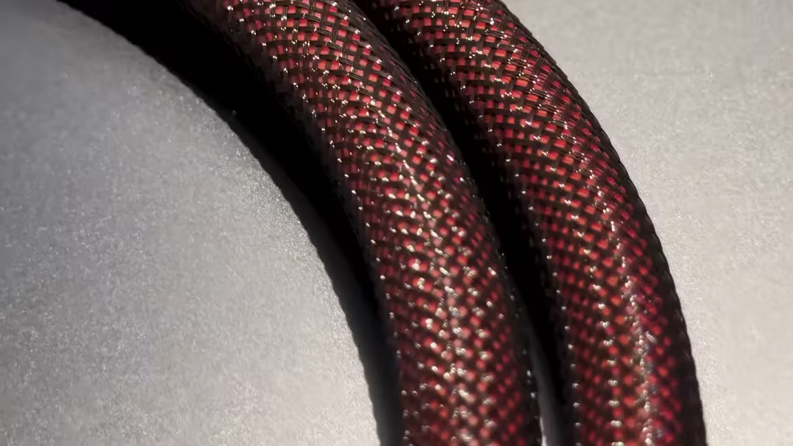 Macro close-up of the cable's red-and-black woven mesh braid jacket