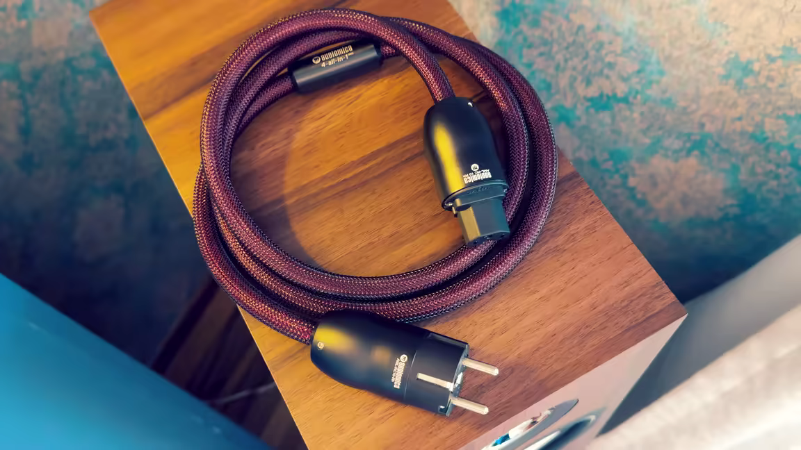 The PRO power cable coiled, showing its central element and the heavy metal Schuko plug and IEC connector