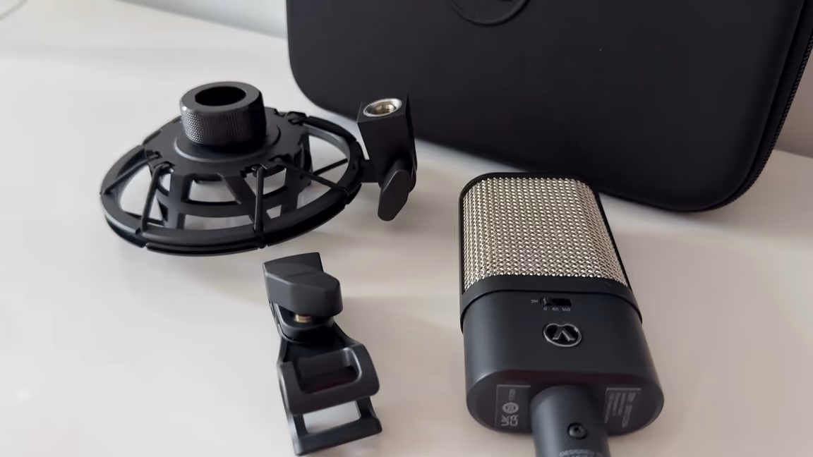 The OC16 laid out beside its elastic spider shockmount and small clip mount, the zip case behind