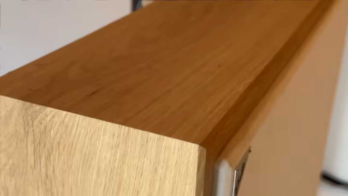A three-quarter view of the Woody Queen's top corner, the light wooden frame wrapping the chunky 15cm panel depth