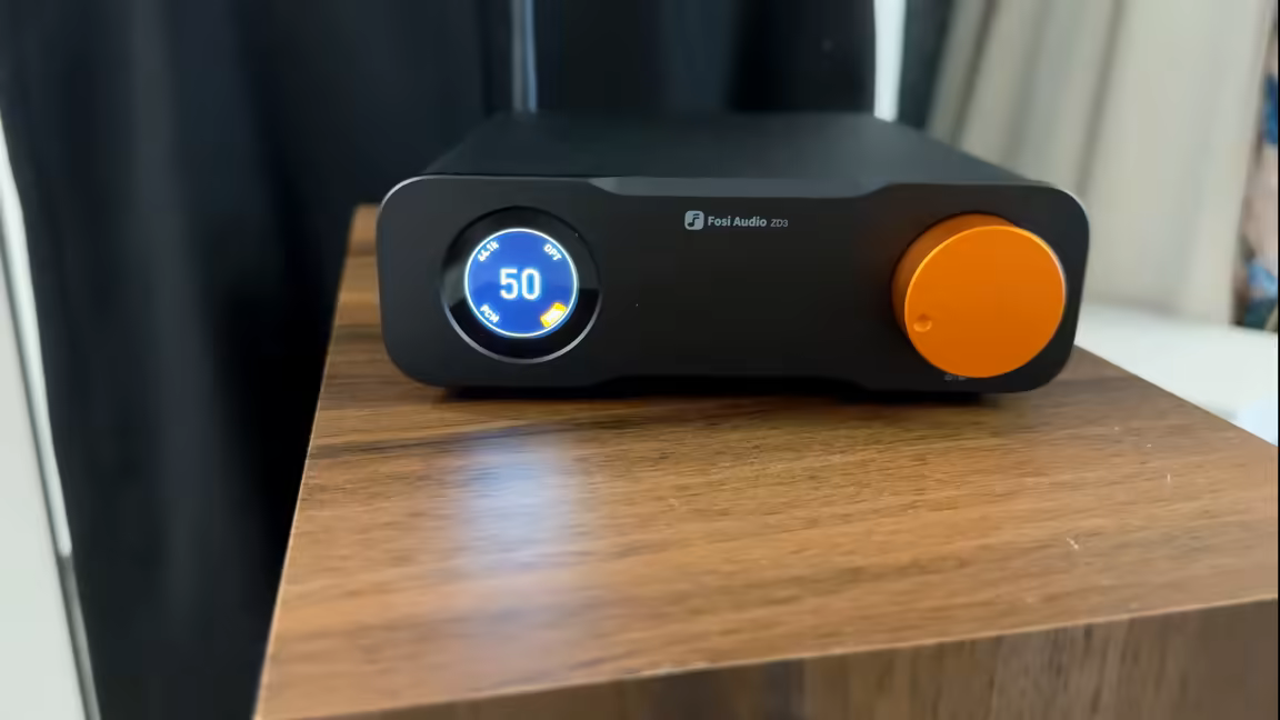 The Fosi Audio ZD3's front panel: the round display reading volume 50 with GAIN, OPT and PCM labels, the Fosi Audio ZD3 logo, and the large orange volume knob
