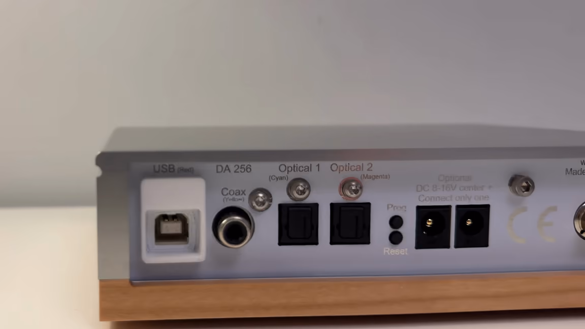 The DA 256's rear panel, labelled left to right: USB, Coax, Optical 1, Optical 2, the stacked Prog and Reset buttons, and two DC barrel jacks marked Optional DC 8-16V center + Connect only one