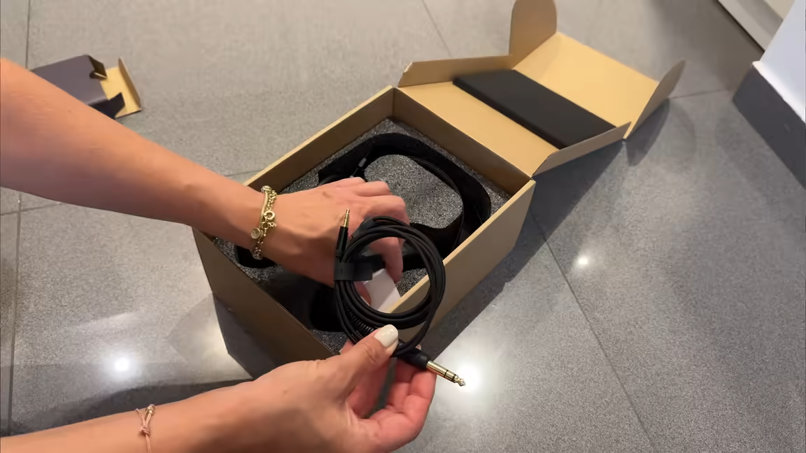 The Arya Stealth's braided stock cable held over the box, ending in a quarter-inch plug with a large strain relief