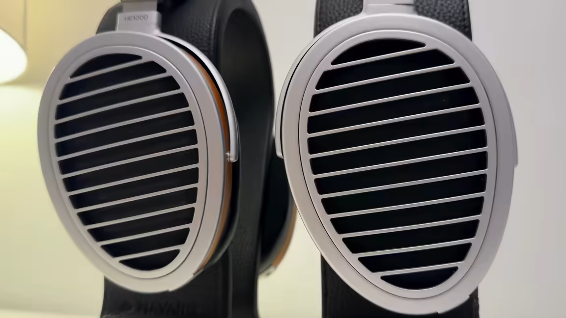 Front view of the HIFIMAN HE1000se's open-back cups: the patented Window Shade grille of horizontal aluminium slats over the planar driver, each cup ringed by a silver frame and a wood-veneer band
