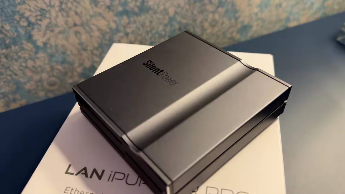 The iFi LAN iPurifier Pro, a dark chamfered-edge metal box marked Silent Power, resting on its box