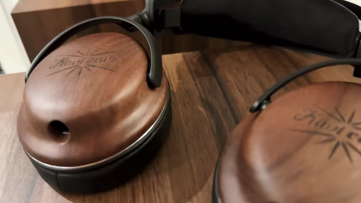 The Kiwi Ears Atheia's walnut wood earcups with the engraved logo and aluminium brackets
