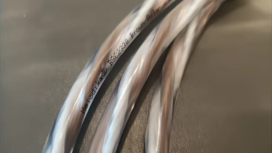 Close-up of the Brown Sugar BSSC3300's twisted brown-and-white conductors under clear insulation, printed with the Melodika model name