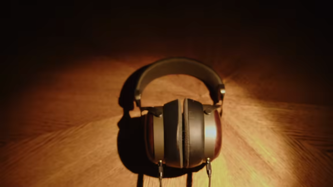 The Sivga SV021 Pro's wooden closed-back earcups, leather headband and soft pads, lit on a dark wooden surface