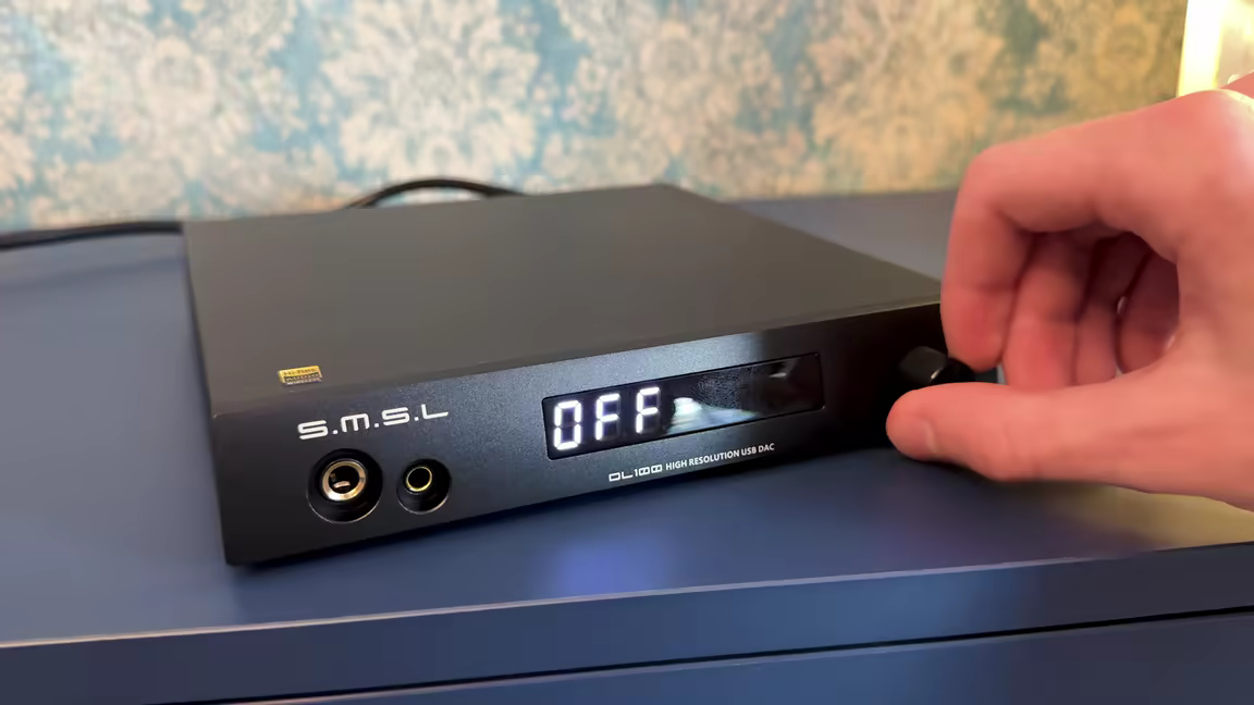 The SMSL DL100's front panel: display, volume knob, and 1/4-inch plus 4.4mm headphone outputs