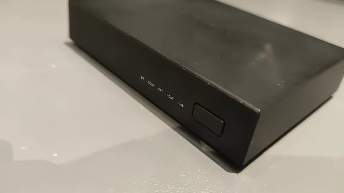 The SMSL PS100's front panel with its white LED input indicators and single input-selector button