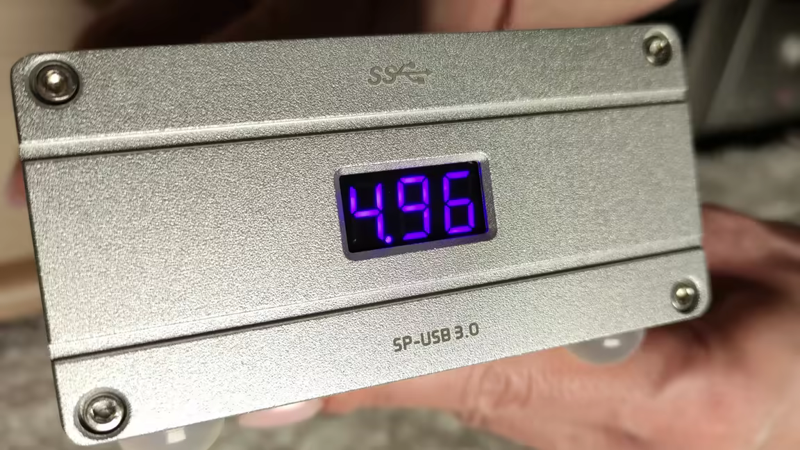 The silver SP-USB's front plate with its blue LED voltage display reading 4.96 volts, beside the USB SuperSpeed logo