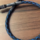 A DH Labs Silver Sonic cable with its blue-and-black braided jacket and machined metal connectors