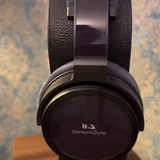 HarmonicDyne Eris on a stand, its glossy black earcup bearing the HarmonicDyne logo