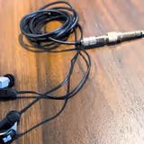 The HIFIMAN RE2000 PRO Silver's CNC aluminium shells, detachable cable, and gold-plated plug on a wooden desk